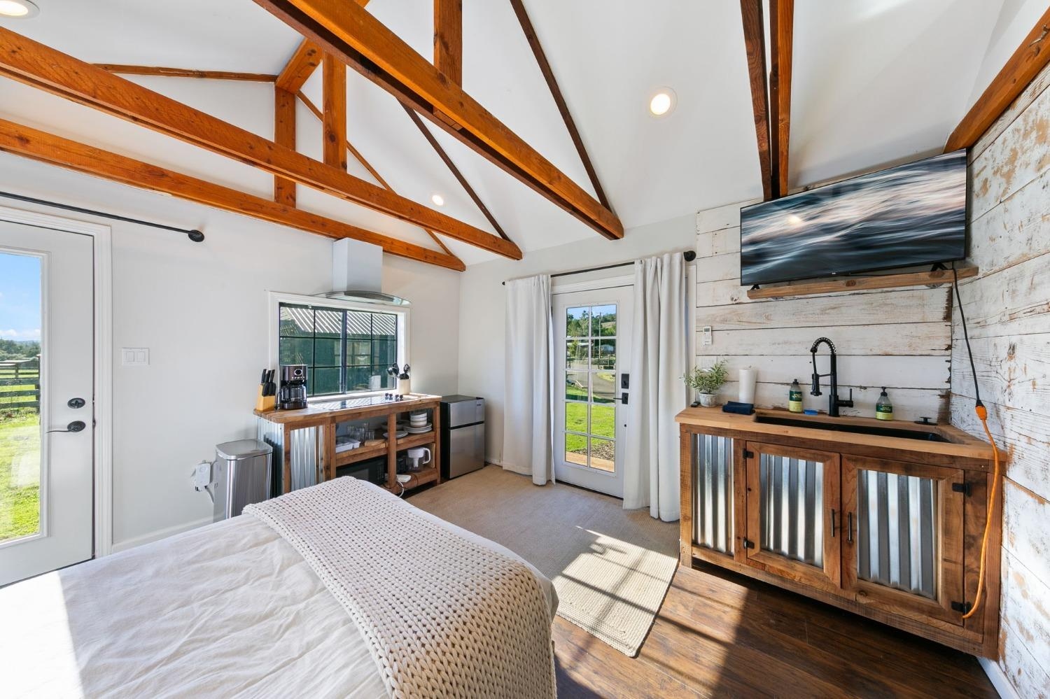 Renovated cabin interior with exposed beams and kitchenette